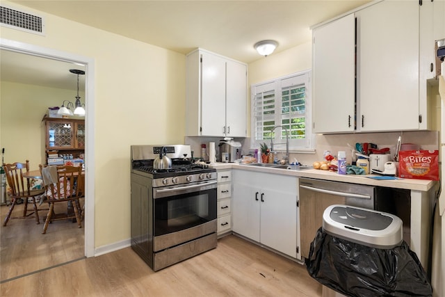 1128 Redbud St, Denison, TX 75020 - kitchen with stainless steel appliances, a sink, light wood-style flooring, and white cabinets