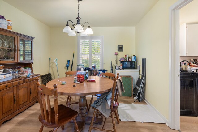 1128 Redbud St, Denison, TX 75020 - dining area with light wood-type flooring and a chandelier