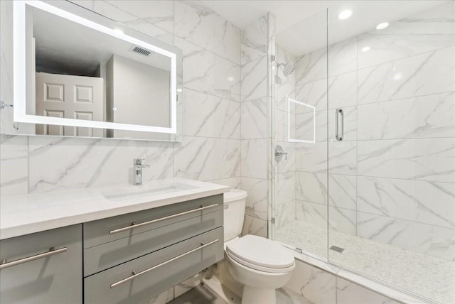 5909 Luther Ln Unit 1002, Dallas, TX 75225 - bathroom with toilet, a marble finish shower, vanity, tasteful backsplash, and tile walls