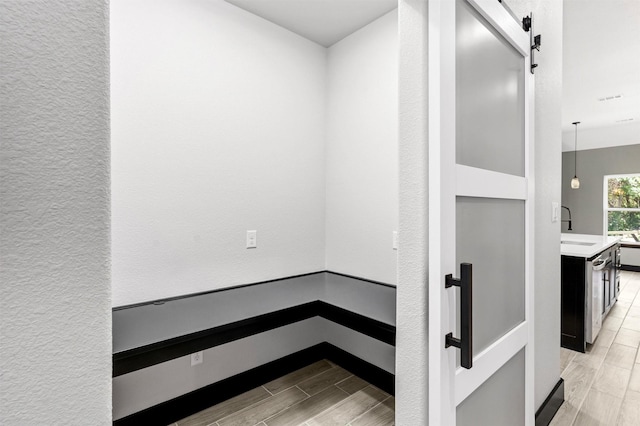 2519 Lakeridge Dr, Granbury, TX 76048 - hall featuring wood tiled floors, a barn door, and baseboards