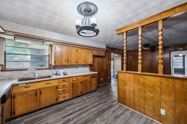 4518 Live Oak Dr, Mesquite, TX 75150 - kitchen with a sink, brown cabinetry, decorative backsplash, a chandelier, and wood walls