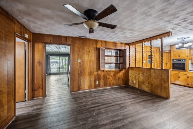 4518 Live Oak Dr, Mesquite, TX 75150 - unfurnished living room featuring wood walls, ceiling fan, and wood finished floors