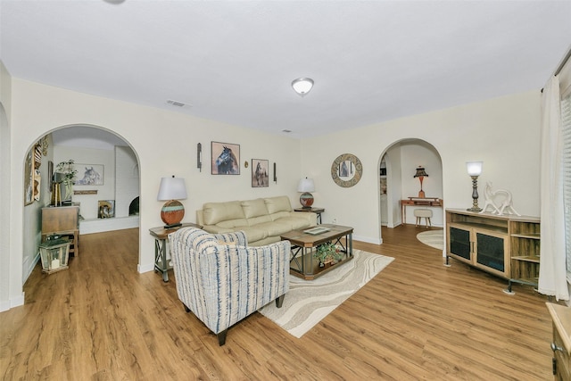 7616 Circle Dr, North Richland Hills, TX 76180 - living room with arched walkways, light wood-style floors, and baseboards