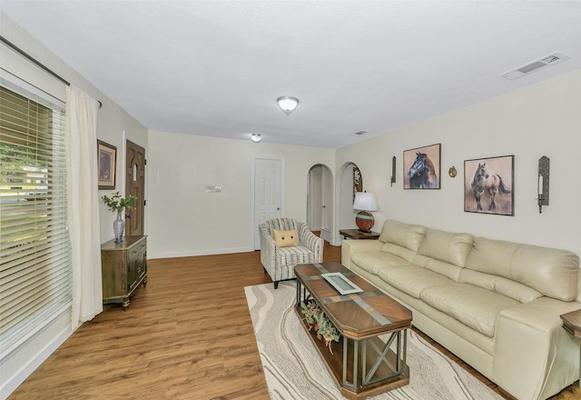 7616 Circle Dr, North Richland Hills, TX 76180 - living room with arched walkways, light wood finished floors, and baseboards