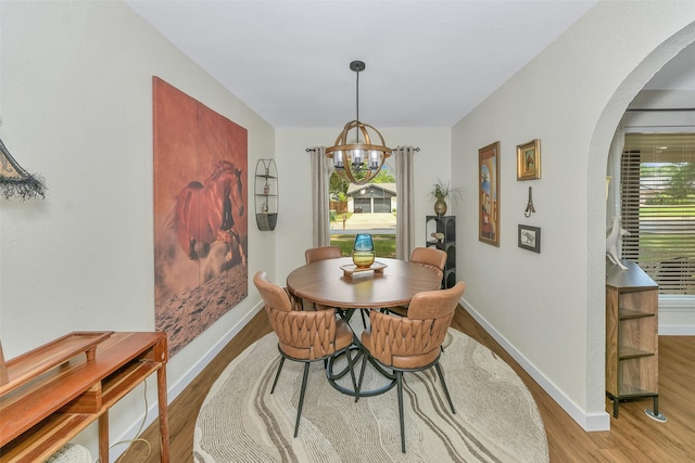7616 Circle Dr, North Richland Hills, TX 76180 - dining room featuring arched walkways, a chandelier, wood finished floors, and baseboards