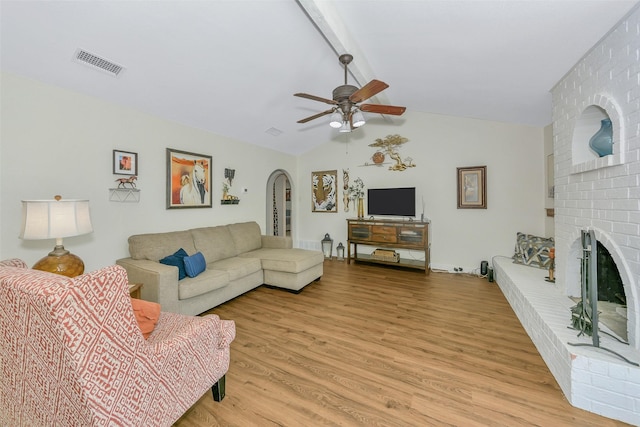 7616 Circle Dr, North Richland Hills, TX 76180 - living area with a ceiling fan, light wood finished floors, a fireplace, and arched walkways