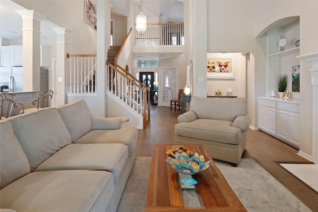 4620 Friars Ln, Grand Prairie, TX 75052 - living area with wood finished floors, a towering ceiling, stairs, and decorative columns