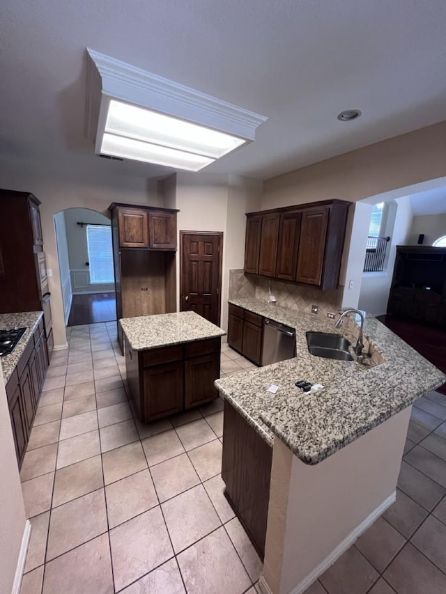 8205 Fountain Springs Dr, Plano, TX 75025 - kitchen featuring a sink, arched walkways, a peninsula, stainless steel dishwasher, and light tile patterned floors
