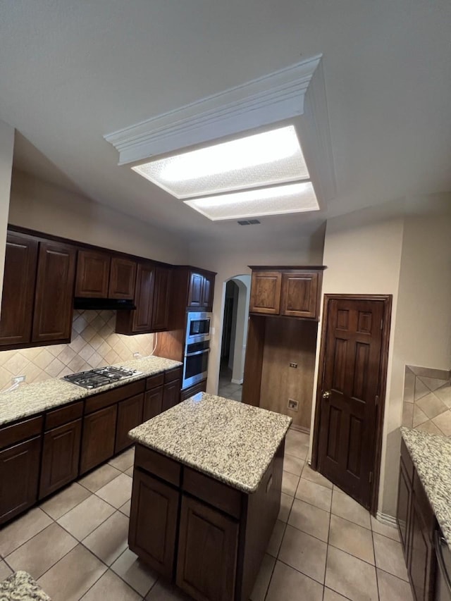 8205 Fountain Springs Dr, Plano, TX 75025 - kitchen with appliances with stainless steel finishes, arched walkways, backsplash, and light tile patterned floors