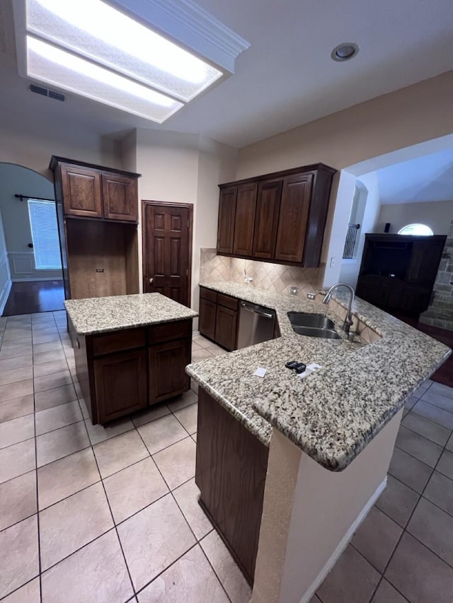 8205 Fountain Springs Dr, Plano, TX 75025 - kitchen with a sink, stainless steel dishwasher, a peninsula, light stone countertops, and dark brown cabinetry