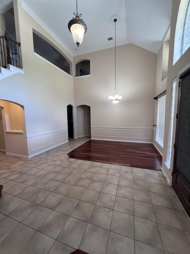 8205 Fountain Springs Dr, Plano, TX 75025 - entrance foyer with high vaulted ceiling, a decorative wall, arched walkways, tile patterned flooring, and a chandelier
