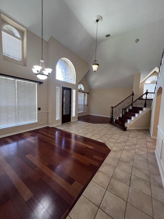 8205 Fountain Springs Dr, Plano, TX 75025 - foyer with stairs, a chandelier, baseboards, high vaulted ceiling, and wood finished floors