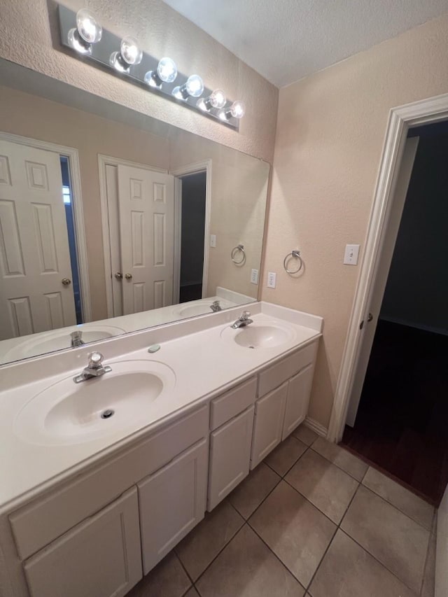 8205 Fountain Springs Dr, Plano, TX 75025 - bathroom featuring a textured wall, a textured ceiling, tile patterned flooring, and double vanity
