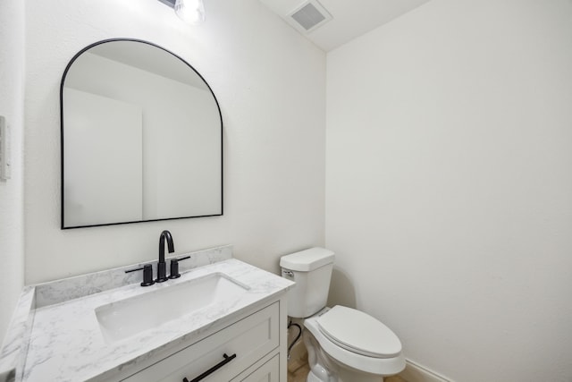 half bath featuring vanity, toilet, and baseboards