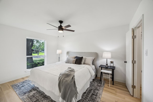 bedroom featuring light wood finished floors, ceiling fan, and baseboards