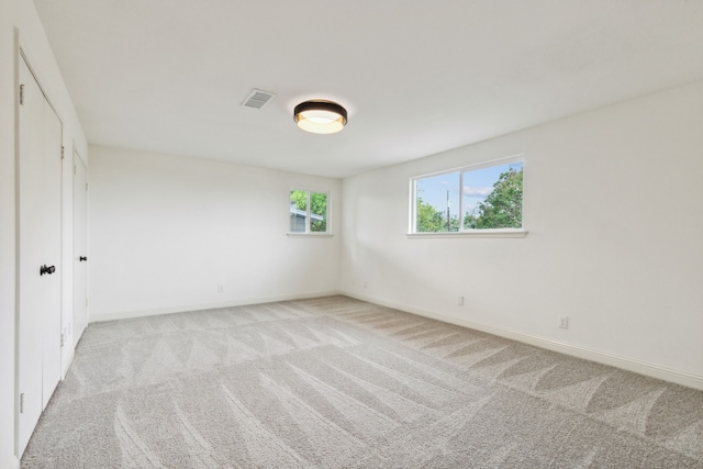 empty room with light carpet and baseboards