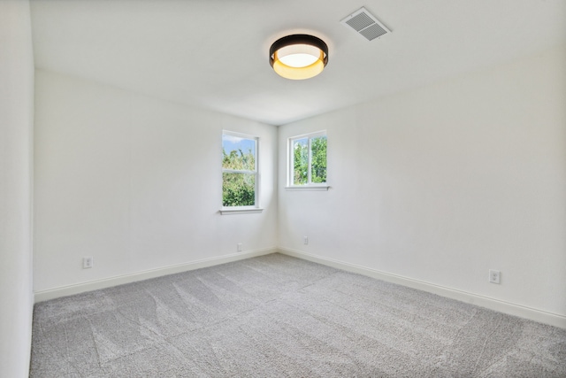 empty room featuring baseboards and carpet