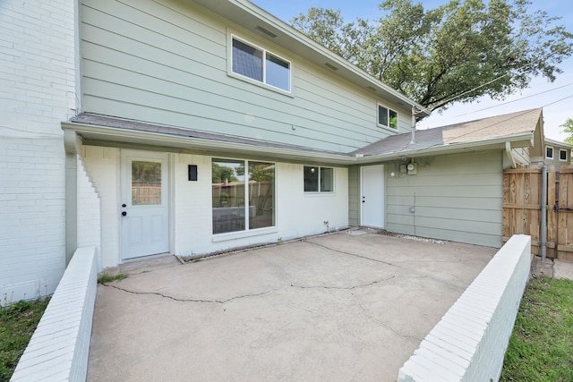 back of house with brick siding, a patio, and fence