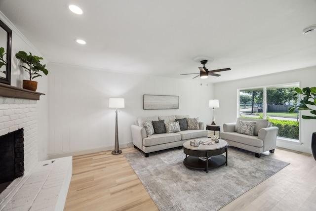 living room featuring ceiling fan, wood finished floors, a brick fireplace, and recessed lighting
