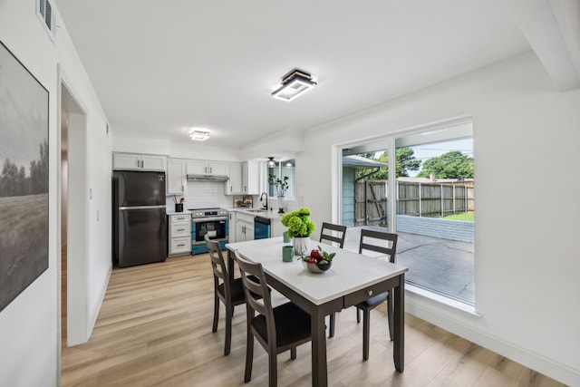 dining room with light wood-style flooring and baseboards