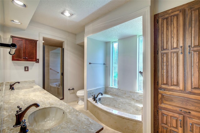 3438 Morning Star Ln, Garland, TX 75043 - bathroom with toilet, a bath, double vanity, a textured ceiling, and recessed lighting
