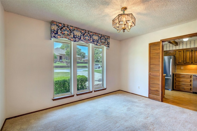 3438 Morning Star Ln, Garland, TX 75043 - unfurnished dining area with light colored carpet, a chandelier, a textured ceiling, and baseboards