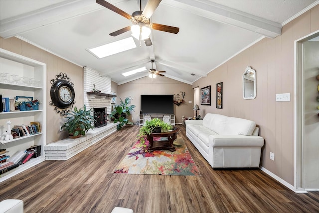 7223 Fm 2494, Athens, TX 75751 - living room featuring ceiling fan, wood finished floors, a brick fireplace, a skylight, and crown molding