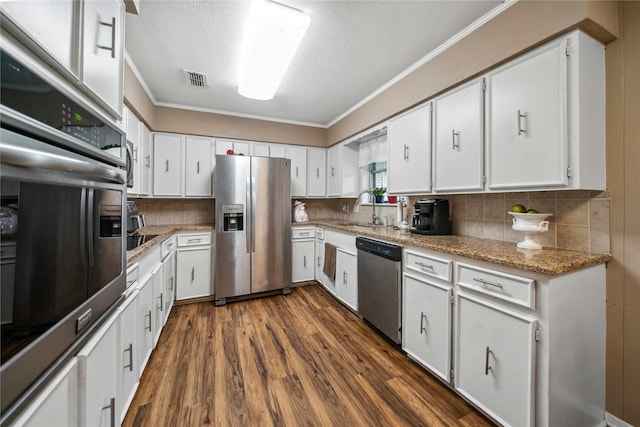7223 Fm 2494, Athens, TX 75751 - kitchen featuring stainless steel appliances, a sink, ornamental molding, dark wood finished floors, and white cabinetry