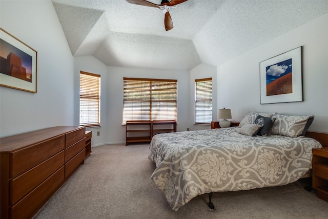 bedroom with light colored carpet, vaulted ceiling, a ceiling fan, and a textured ceiling