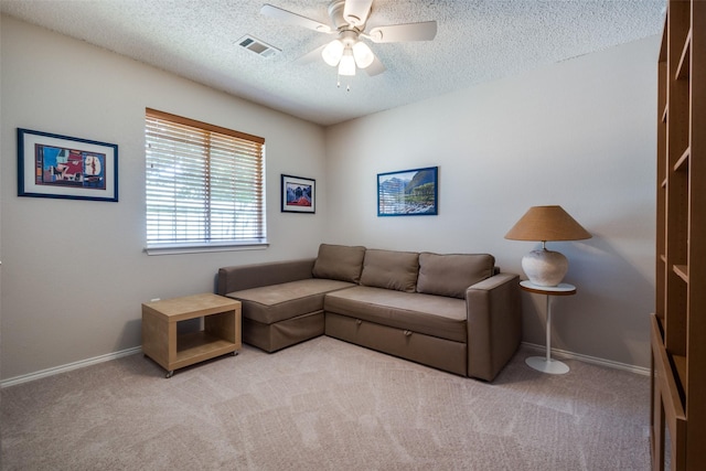 living room with a ceiling fan, a textured ceiling, carpet floors, and baseboards