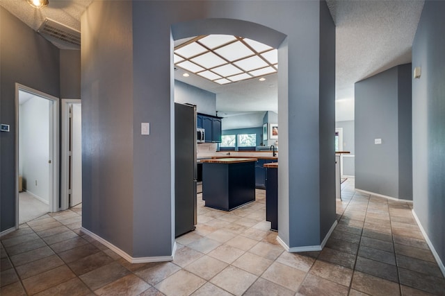 corridor featuring arched walkways and baseboards