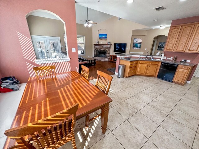 4317 Bay Meadow Dr, Denton, TX 76210 - dining room with arched walkways, ceiling fan, a stone fireplace, light tile patterned floors, and lofted ceiling
