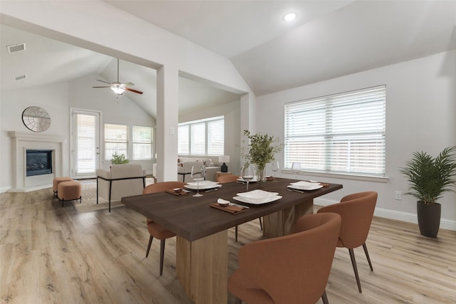 771 Elm Park Dr, Prosper, TX 75078 - dining room with lofted ceiling, light wood-style floors, baseboards, ceiling fan, and a glass covered fireplace