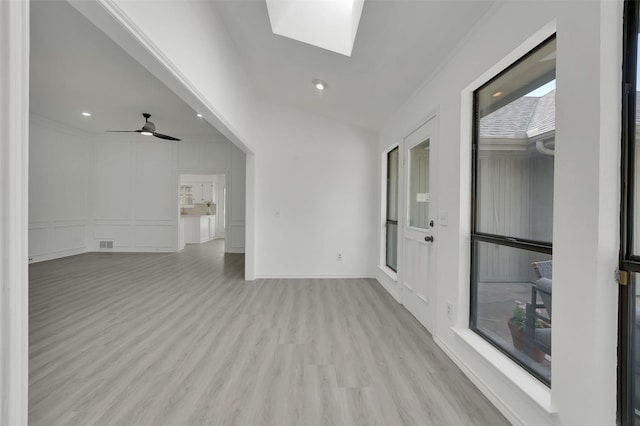 2541 Belmeade Dr, Carrollton, TX 75006 - spare room featuring light wood-style floors, a skylight, a decorative wall, recessed lighting, and baseboards