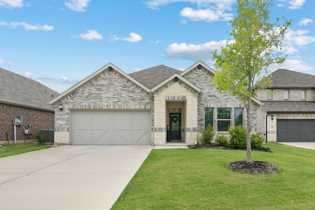 3112 Kingsgarden Rd, Denton, TX 76207 - french country inspired facade with central AC unit, driveway, a front yard, an attached garage, and stone siding
