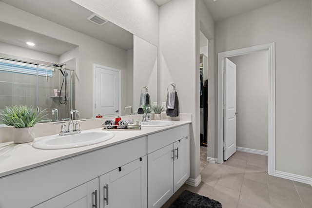 3112 Kingsgarden Rd, Denton, TX 76207 - full bathroom featuring a stall shower, double vanity, tile patterned flooring, baseboards, and a walk in closet