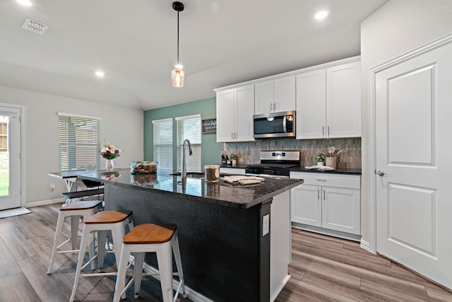 3112 Kingsgarden Rd, Denton, TX 76207 - kitchen featuring appliances with stainless steel finishes, light wood-style flooring, decorative backsplash, recessed lighting, and a breakfast bar