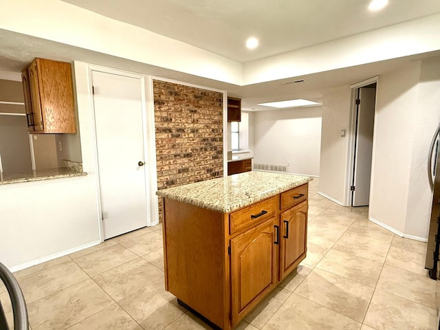 kitchen with light tile patterned floors, light stone countertops, brown cabinets, baseboards, and recessed lighting