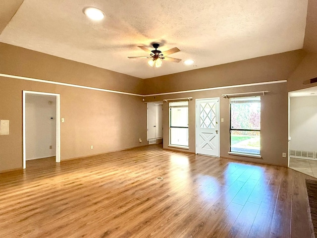 spare room with ceiling fan, wood finished floors, and a textured ceiling