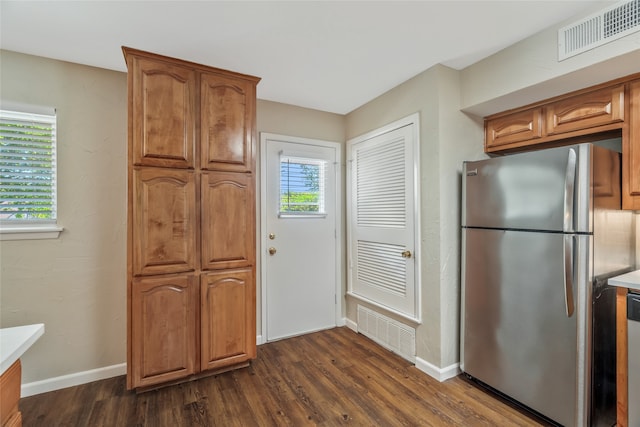 kitchen featuring stainless steel appliances, dark wood-style floors, light countertops, and brown cabinetry