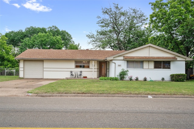 ranch-style house featuring a front lawn, an attached garage, and concrete driveway