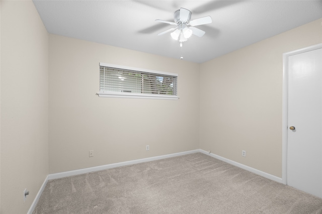 unfurnished room featuring light carpet, a ceiling fan, and baseboards