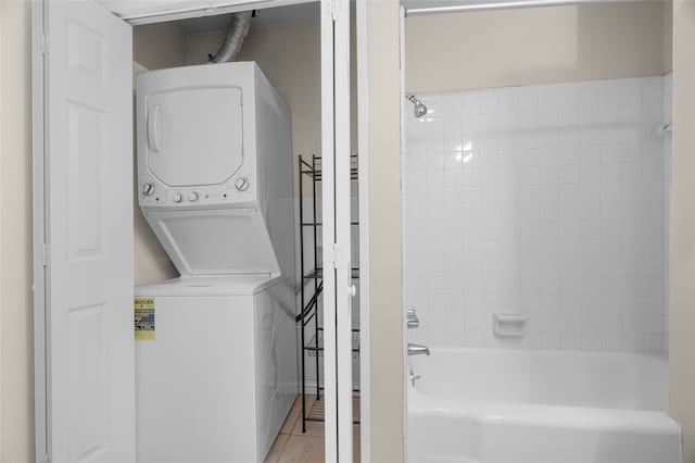 washroom with stacked washer / dryer and light tile patterned flooring
