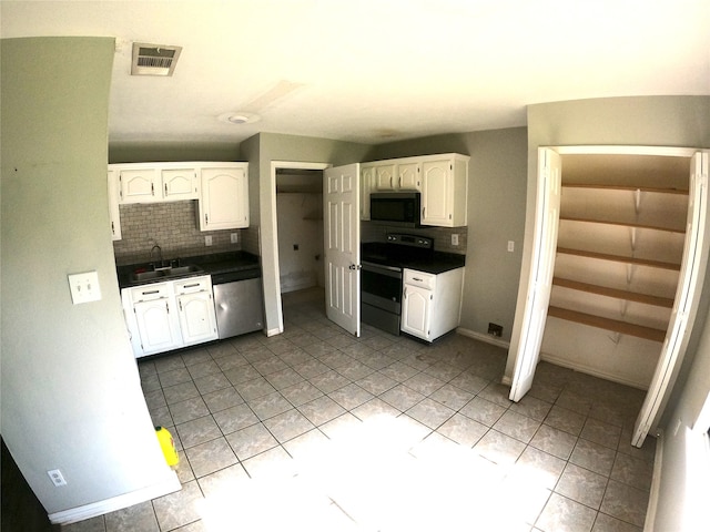 7301 Wayfarer Trl, Fort Worth, TX 76137 - kitchen featuring appliances with stainless steel finishes, white cabinetry, decorative backsplash, a sink, and dark countertops
