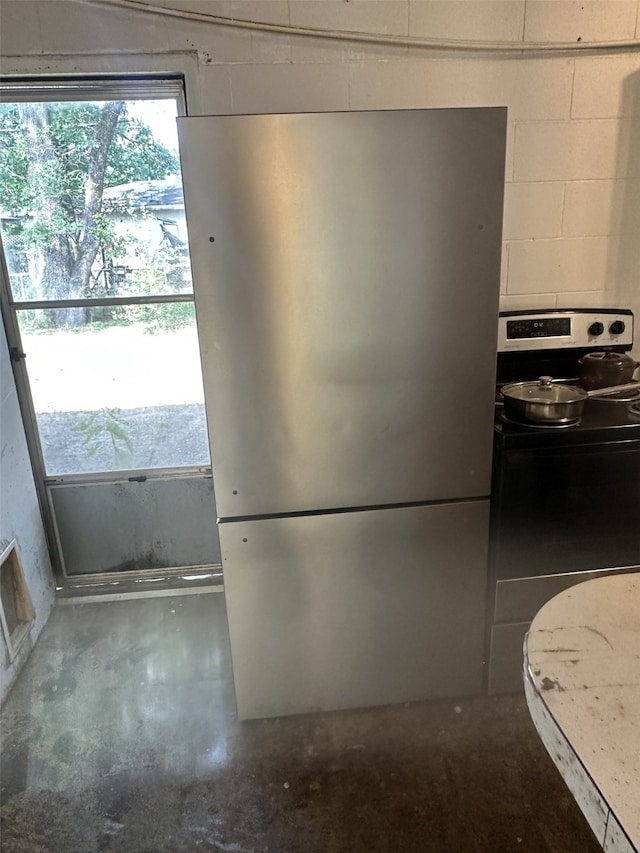 1505 Grove Dr, West Tawakoni, TX 75474 - kitchen featuring appliances with stainless steel finishes, concrete floors, and concrete block wall