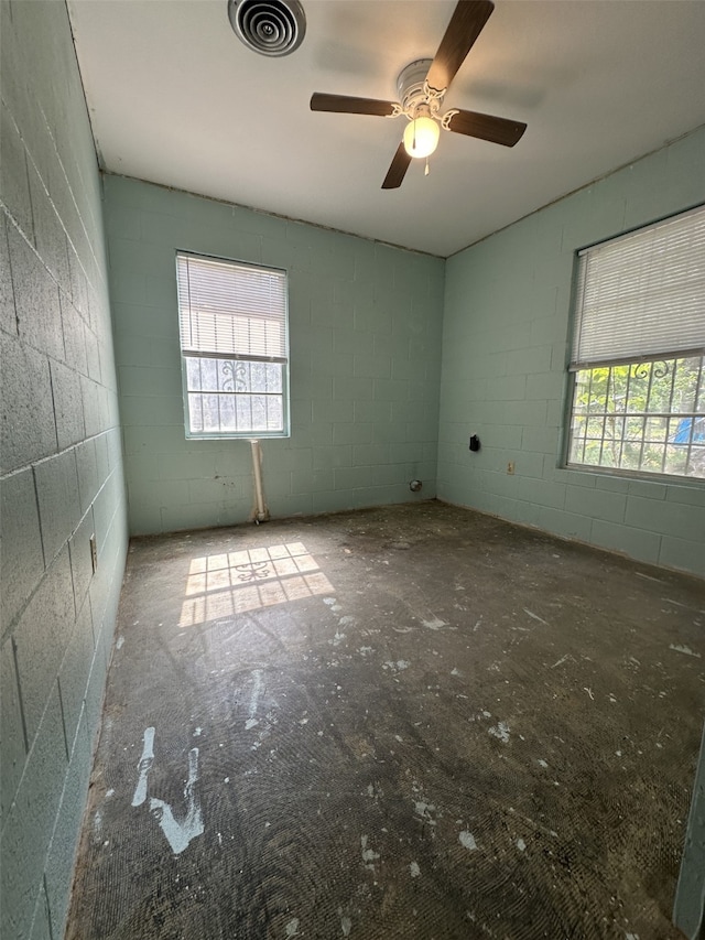 1505 Grove Dr, West Tawakoni, TX 75474 - unfurnished room featuring plenty of natural light, a ceiling fan, and concrete block wall