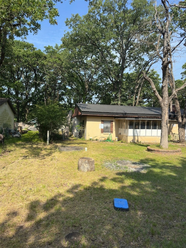 1505 Grove Dr, West Tawakoni, TX 75474 - back of property with a lawn, stucco siding, and metal roof