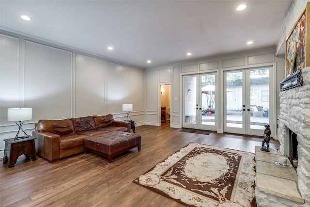 3552 Granada Ave Unit B, University Park, TX 75205 - living room with a decorative wall, crown molding, wood finished floors, french doors, and a stone fireplace