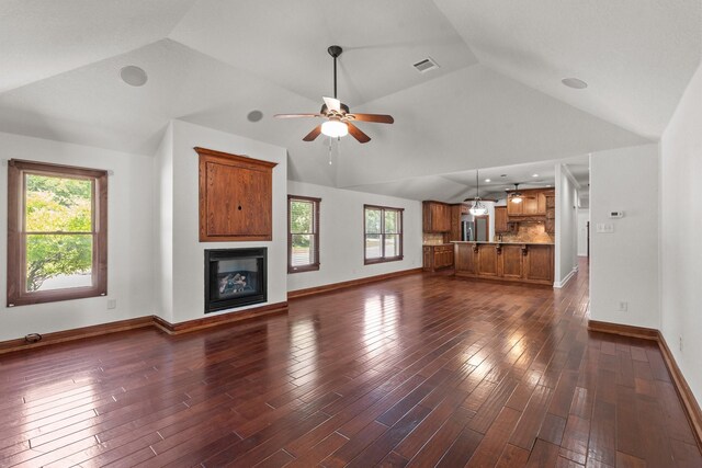 2100 Tremont Ave, Fort Worth, TX 76107 - unfurnished living room featuring lofted ceiling, a ceiling fan, plenty of natural light, baseboards, and dark wood-style flooring