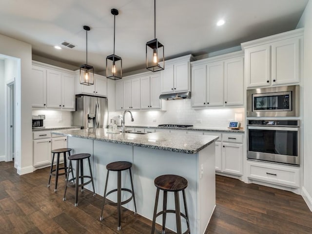 916 Timber Ridge Dr, Justin, TX 76247 - kitchen featuring appliances with stainless steel finishes, under cabinet range hood, backsplash, recessed lighting, and dark wood-style floors
